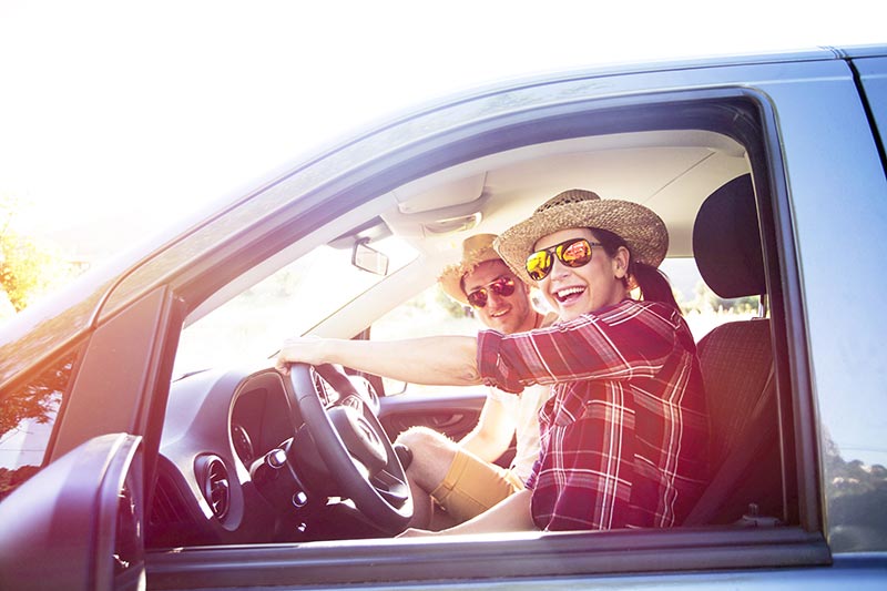 Junges Paar im Auto - Ab in den Urlaub